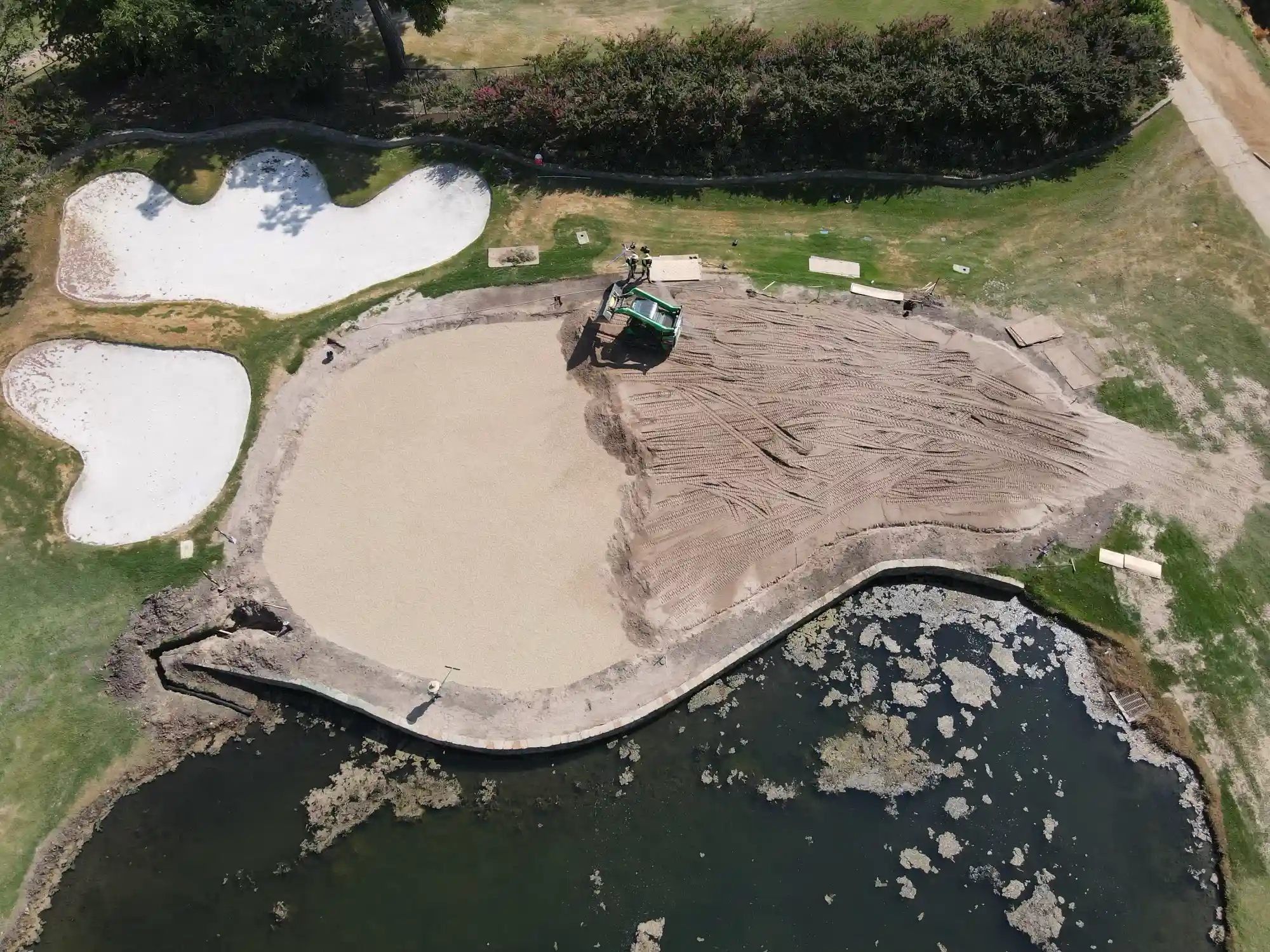 An aerial view of sand and aggregate being used in the construction of a golf course feature.