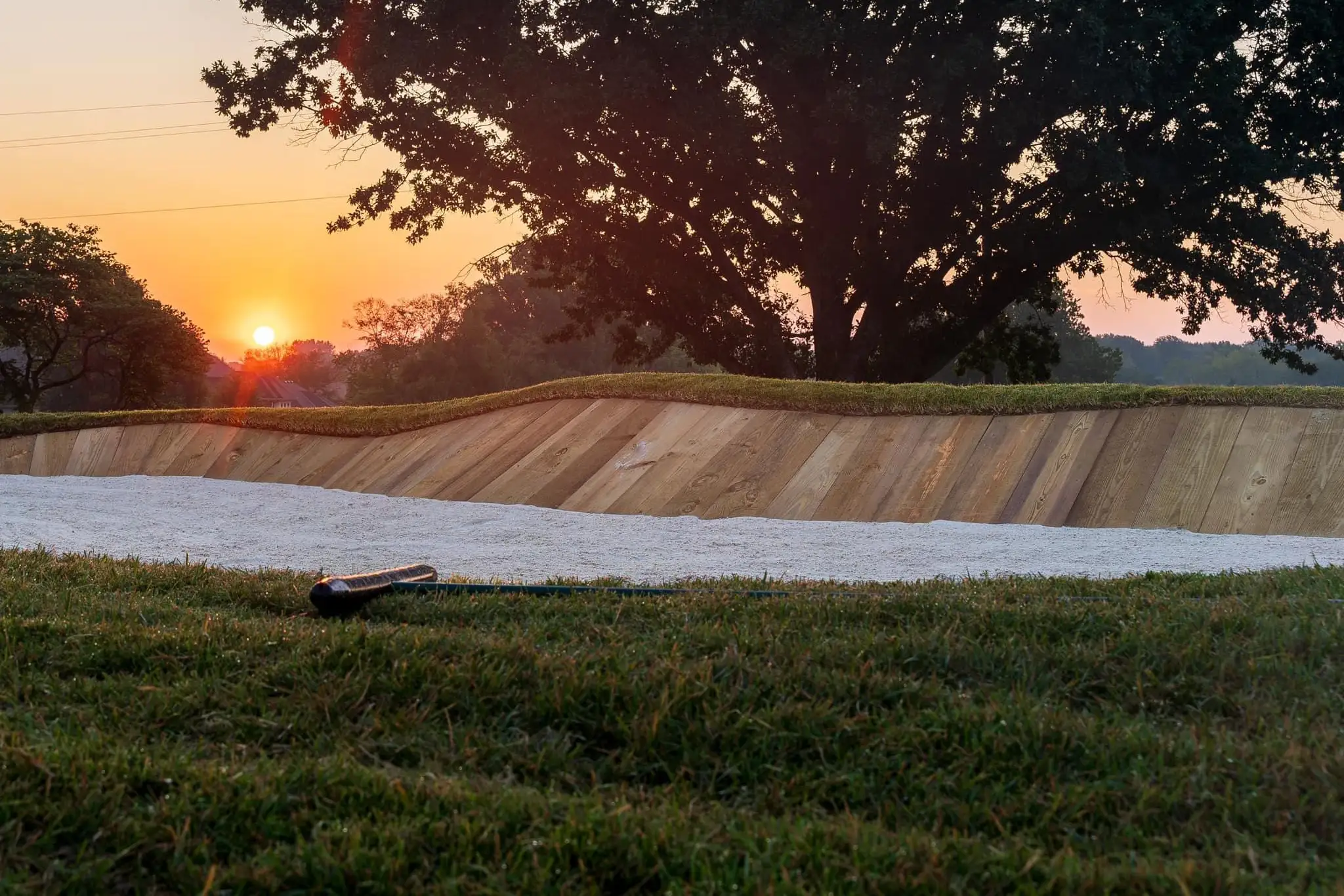 The sun sets on a sand bunker at Dubs Dread Golf Club in Kansas City, KS.